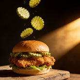 ACIDE Dill Cucumber Chips crinkle-cut pickles freeze-frame falling onto a charcuterie board