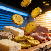 ACIDE Bread and Butter Zucchini Pickles freeze-frame falling onto a charcuterie board