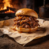 Pulled pork sandwich on a brioche bun with glossy amber sauce dripping down the side