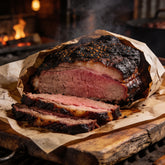 Whole smoked brisket sliced open on butcher paper showing a deep pink smoke ring