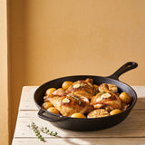Outlaw Barbecue Gold Rush 280g garlic butter BBQ rub — golden garlic-butter roast chicken thighs with potatoes in a cast-iron pan