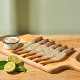 Outlaw Barbecue Lawless 220g lime and black pepper BBQ rub — raw king prawns seasoned and ready to cook with limes