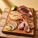 Outlaw Barbecue four pack BBQ rub bundle — raw steak, chicken, prawns and lamb chops each seasoned with a different blend