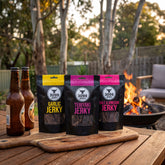 3099 Jerky 3-pack — Garlic, Teriyaki and Salt & Vinegar beef jerky on a grazing board by the fire
