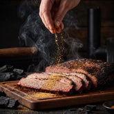 Heavenly Hell Diggers Dust finishing dust 150g — a hand sprinkling the dust over freshly sliced smoked brisket