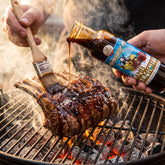 Lamb Almighty glaze brushed onto a rack of lamb on the grill
