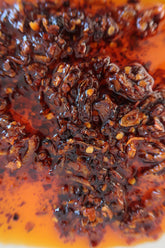 Close-up of Ma Foo Chilli Oil showing crispy shallot, chilli flake and seeds in amber-red oil
