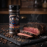 Heavenly Hell Pistol Powder espresso beef rub 150g — shaker beside a sliced steak with a dark espresso crust and coffee beans