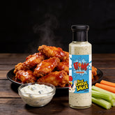 Atomic Chicken Blue Cheese Sauce 250ml — bowl of buffalo wings with the bottle and creamy blue cheese dip