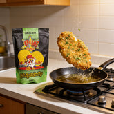 Atomic Chicken Chicken Schnitzel Herb & Garlic Coating 450g — crumbed schnitzel frozen mid-drop into a hot frying pan