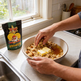 Atomic Chicken Chicken Stuffing 500g — hands mixing the stuffing with butter and stock in a bowl at the kitchen bench
