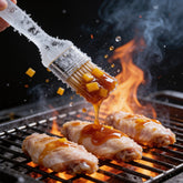Atomic Chicken Honey Mango BBQ Sauce 250ml — sauce being brushed onto wings on a flaming grill, frozen mid-motion