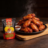 Atomic Chicken Hot 'N Spicy Southern Fried Chicken Coating 500g — steaming plate of glossy chilli-glazed wings with dipping sauce beside the pack