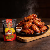 Atomic Chicken Hot 'N Spicy Southern Fried Chicken Coating 500g — steaming plate of glossy chilli-glazed wings with dipping sauce beside the pack
