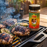 Atomic Chicken Jamaican Jerk Seasoning Rub — jerk chicken thighs with a charred aromatic crust on the grill with thyme and lime