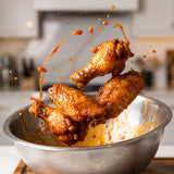Barbecue Mafia The Snitch BBQ Rub — crispy chicken wings tossed in glossy sauce mid-air