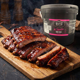 Barbecue Mafia The Squealer BBQ Rub 2kg — a board of sticky glazed pork ribs beside the catering tub