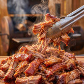 Barbecue Mafia The Squealer BBQ Rub 2kg — freshly pulled pork lifted with tongs, steaming