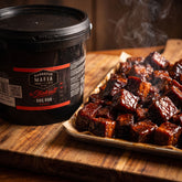 Barbecue Mafia The Steakout BBQ Rub 2kg — a tray of sticky beef burnt ends beside the catering tub