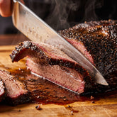 Barbecue Mafia The Steakout BBQ Rub 2kg — carving a dark peppery brisket slice with a smoke ring