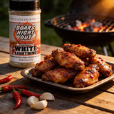 Boars Night Out Spicy White Lightning shaker beside a platter of glazed hot wings with fresh chilli and garlic