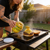 Chuck Hughes Mild Mustard Coleslaw 375ml mustard slaw relish — spooning mustard coleslaw onto a smash burger at the griddle
