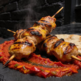 Chuck Hughes Mild Pepper Spread 375ml roasted pepper spread — chargrilled chicken skewers over a swoosh of red pepper spread