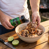 Coast n Smoke Drop-In Jerk rub — cook tossing raw chicken in a wet jerk marinade with lime