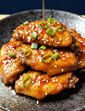 The Smuggler's Gift Crate lifestyle — close-up of glazed chicken wings with sesame and spring onion