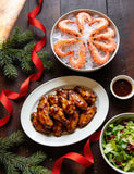The Smuggler's Gift Crate lifestyle — Christmas table with glazed wings, prawns and salad