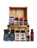The Rub Hub The Kingpin BBQ subscription box — example crate with Blues Hog, The Feedlot, Meat Church, Hardcore Carnivore rubs and gloves, BLEND honey and Boomtang — contents change monthly, on transparent background