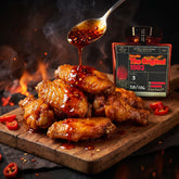 DC Cartel 1983 Extra Hot crispy chilli oil drizzled over glossy barbecue chicken wings on a board