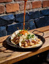 Fancy Hank's Habanero & Carrot Hot Sauce drizzling over shredded chicken soft tacos