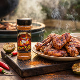 Heavenly Hell Cluckin Hell hot chicken rub 150g — shaker beside a platter of spicy grilled chicken wings on a rustic board