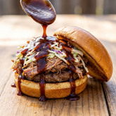Elk Creek Country Style BBQ sauce — a pulled-pork burger with BBQ sauce spooned onto the meat