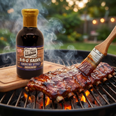 Elk Creek Country Style BBQ sauce — pork ribs mopped with glossy BBQ sauce on a backyard grill