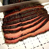 Jimmy Brisket Special Ops 280g beef rub — Jimmy Brisket slicing a smoked brisket with a peppery bark and smoke ring