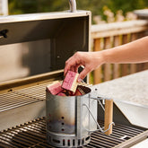 Natural Smoke Cherry wood chunks being added to a smoker box on the BBQ