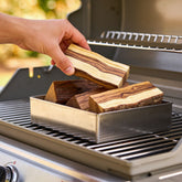 Natural Smoke Olive wood chunks being added to a smoker box on the BBQ