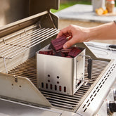 Natural Smoke Red Gum wood chunks being added to a smoker box on the BBQ