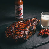 Nomad Chilli Co Reaper Roja hot sauce — grilled ribeye steak with a reaper chilli marinade on dark slate