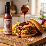 Nomad Chilli Co The BBQ Sauce bbq sauce — dark red BBQ sauce spooned onto an open double cheeseburger, bottle beside