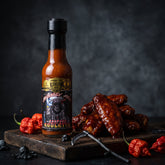 Reapers Roulette Carolina Reaper hot sauce styled with saucy wings and chillies