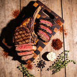 Plowboys Bovine Bold Rub on a sliced tomahawk steak and smoked brisket — beauty shot on butcher block