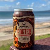 Rum and Que The Porter beer rub can on a beachside table