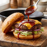 Smoky Pastures Sweet and Sour BBQ sauce — spooned onto an open cheeseburger patty