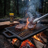 Stef the Maori Deep Bush horopito seasoning — venison steak searing on a cast-iron grate over a bush campfire