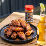 Stef the Maori Pork Hunt pork and chicken seasoning — pile of sticky grilled chicken wings on a plate with a cold beer