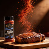 TAIPAN BBQ Aussie All-Rounder all-purpose BBQ rub 175g — action shot, rub granules exploding over a seared steak