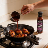 TAIPAN BBQ Bubblegum ultra hot 7 pot chilli BBQ sauce 250ml — in-use shot, pouring sauce over sizzling wings